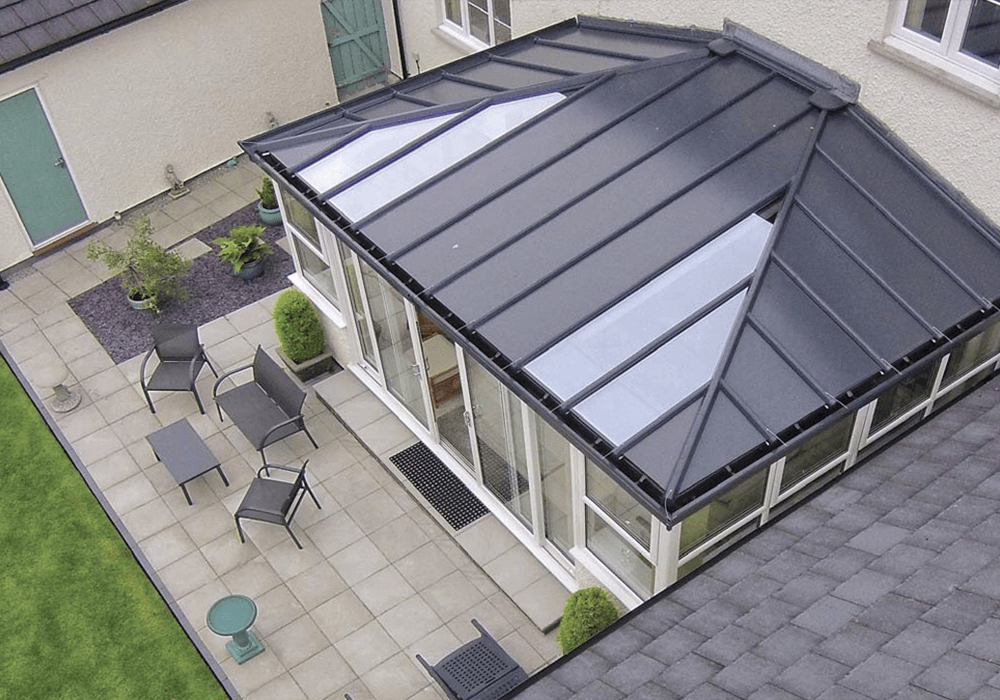 A solid roof conservatory with a few chairs outside.