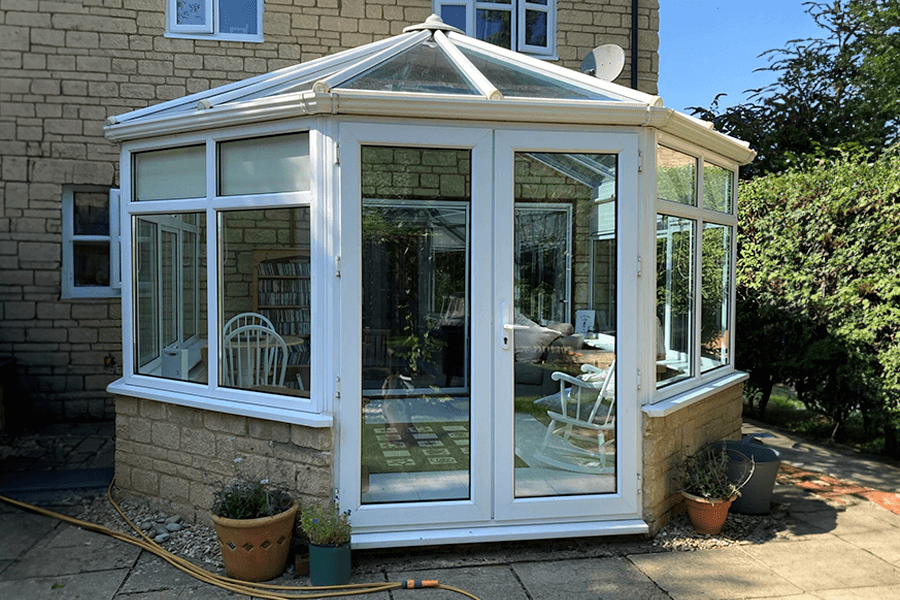 A conservatory with some plant outside.