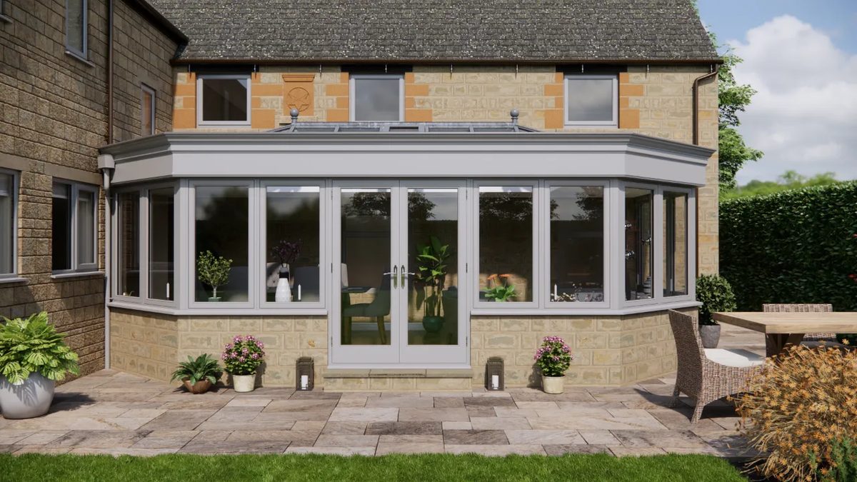 Grey painted orangery with a roof lantern and French doors onto a stone patio